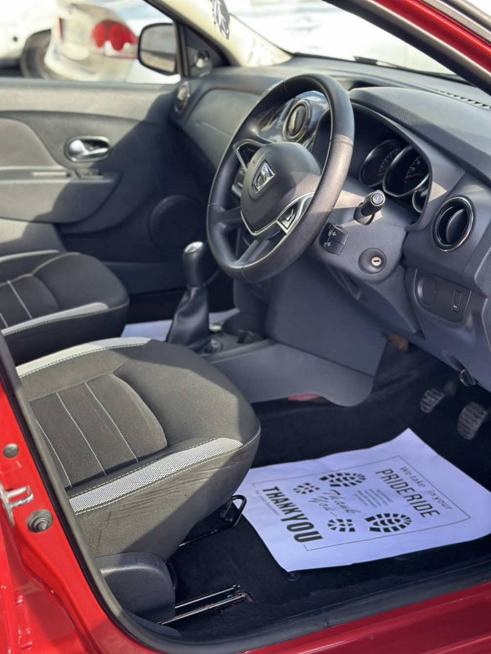 Interior of a clean car showing a paper floor mat with branding.