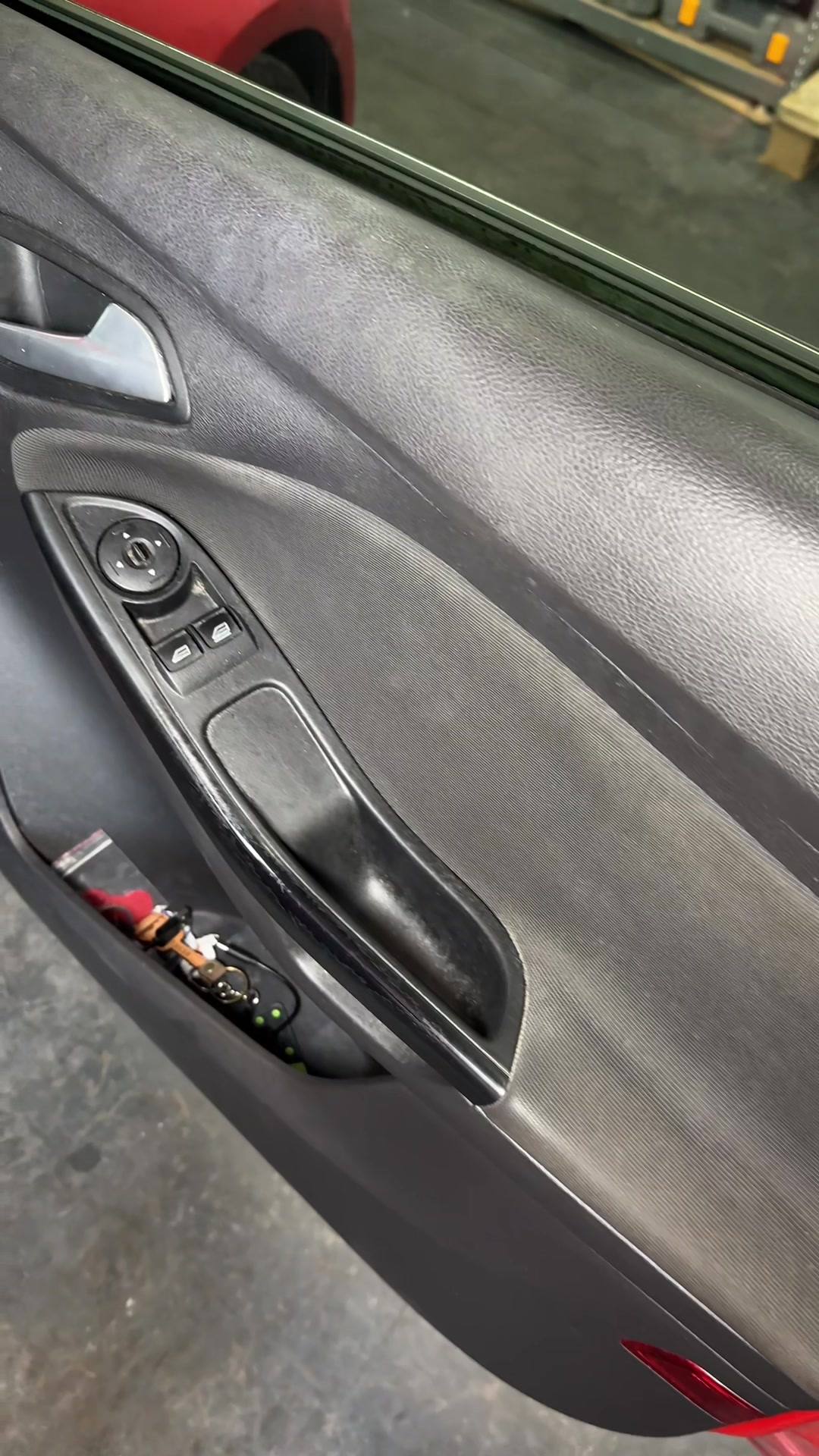 Cleaned interior car door panel with window controls.