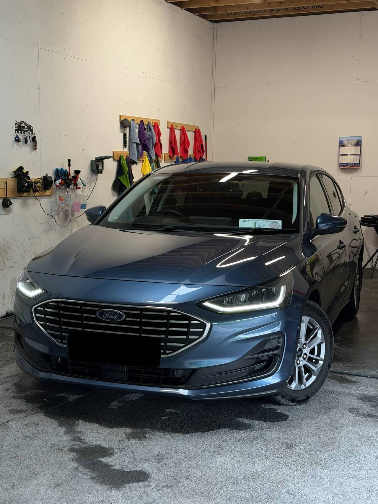 Blue sedan with LED headlights parked in garage